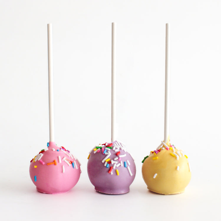 Birthday cake pops decorated in pink, purple and yellow from Bake Sale Toronto.