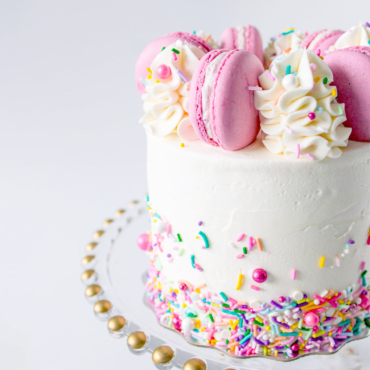 Bake Sale Toronto Sparkle Cake topped with strawberry macarons and vanilla buttercream swirls